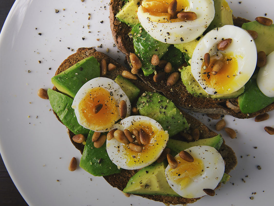 An overhead view of a plate of avocado and egg toast